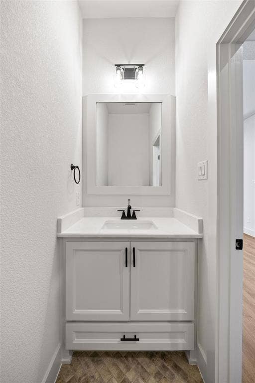 902 Boston Lane, River Oaks, TX 76114 Vanity area featuring a framed mirror, white cabinetry, integrated sink, and matte black fixtures