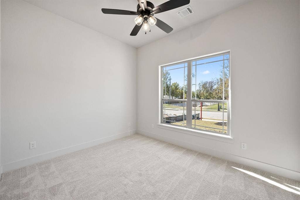 902 Boston Lane, River Oaks, TX 76114 Room featuring light gray carpet flooring, white walls, and a large window with white trim