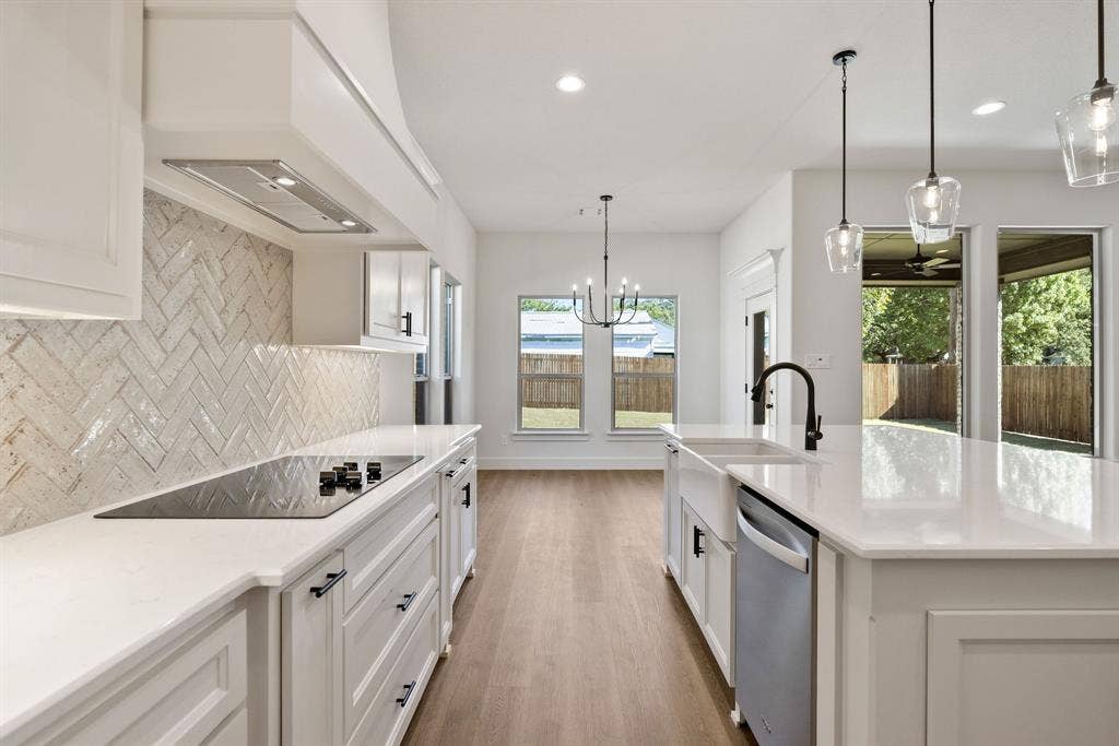 902 Boston Lane, River Oaks, TX 76114 Modern kitchen featuring a large island with a farmhouse sink, stainless steel dishwasher, and pendant lighting