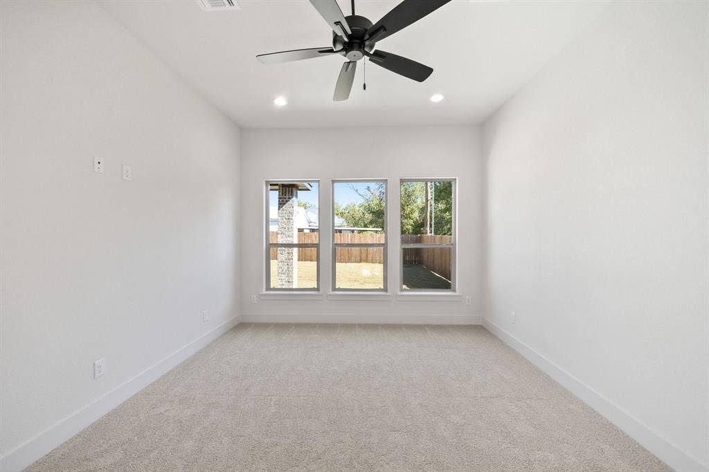 902 Boston Lane, River Oaks, TX 76114 Bright room featuring a ceiling fan with integrated lighting, three large windows, recessed lighting, and carpet flooring