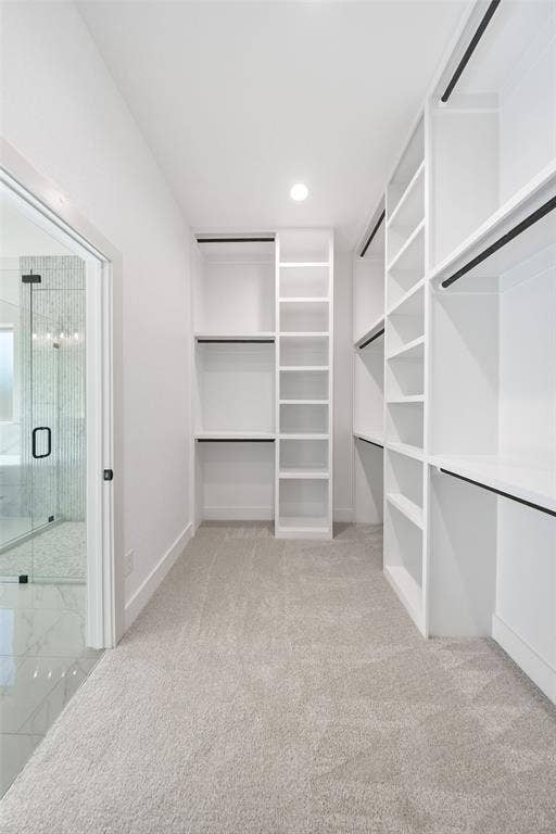 902 Boston Lane, River Oaks, TX 76114 Walk-in closet featuring light grey carpeting and extensive built-in white shelving