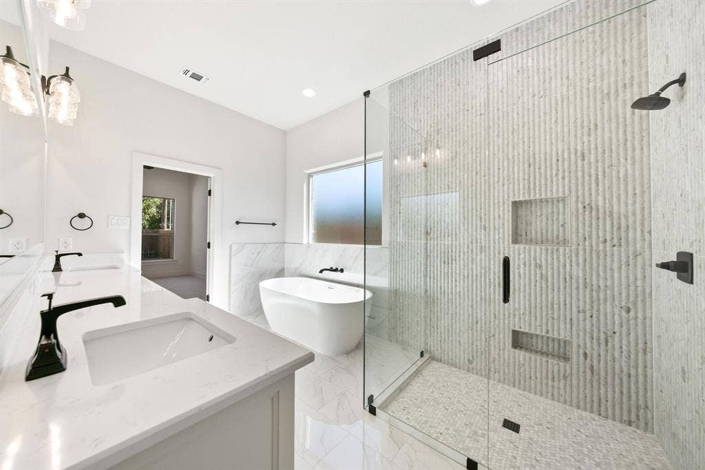 902 Boston Lane, River Oaks, TX 76114 Contemporary bathroom featuring a frameless glass shower enclosure with textured tile walls and two recessed niches