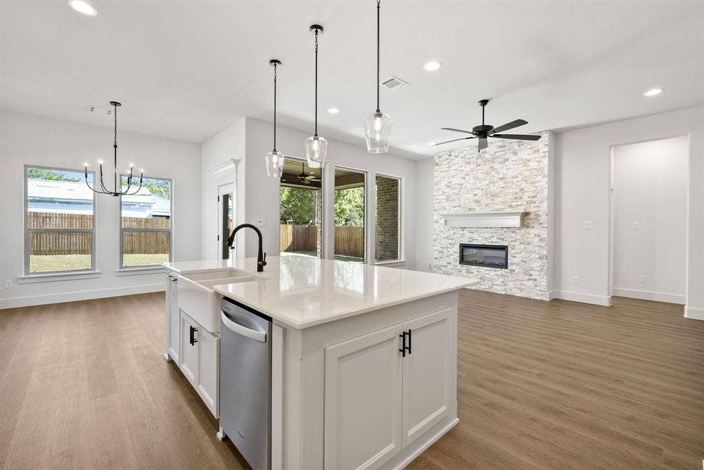 902 Boston Lane, River Oaks, TX 76114 Kitchen island featuring a farmhouse sink, stainless steel dishwasher, and quartz countertop