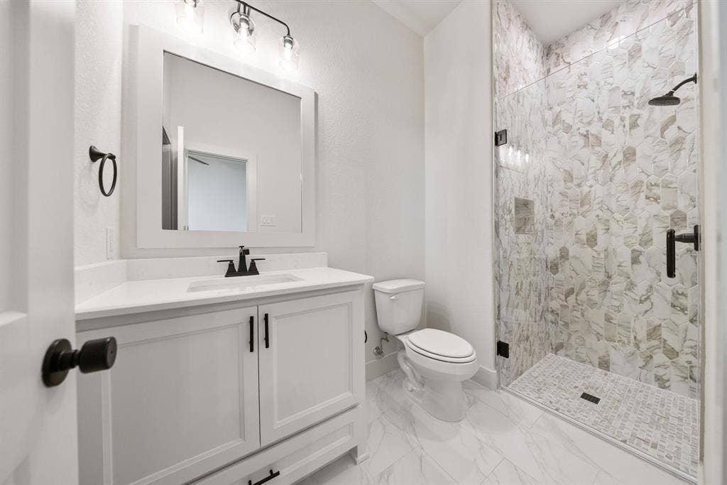 902 Boston Lane, River Oaks, TX 76114 Contemporary bathroom featuring a frameless glass shower enclosure with patterned tile surround and a tiled shower pan