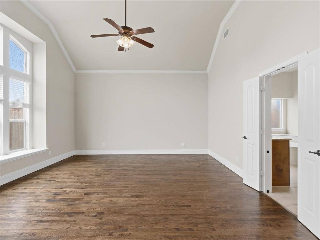 1621 Lakemere Drive, Prosper, TX 75078 Spacious room featuring vaulted ceilings, wood-finish flooring, and a contemporary ceiling fan
