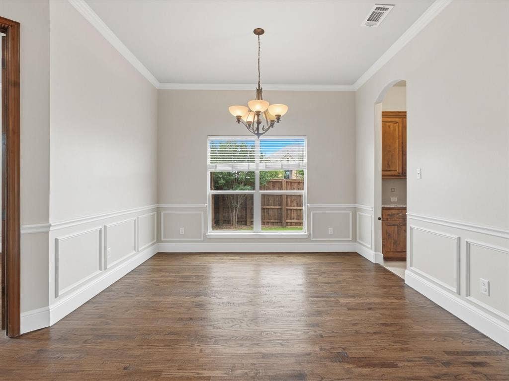1621 Lakemere Drive, Prosper, TX 75078 Formal dining space featuring wood-finish flooring, wainscoting, crown molding, and a central chandelier
