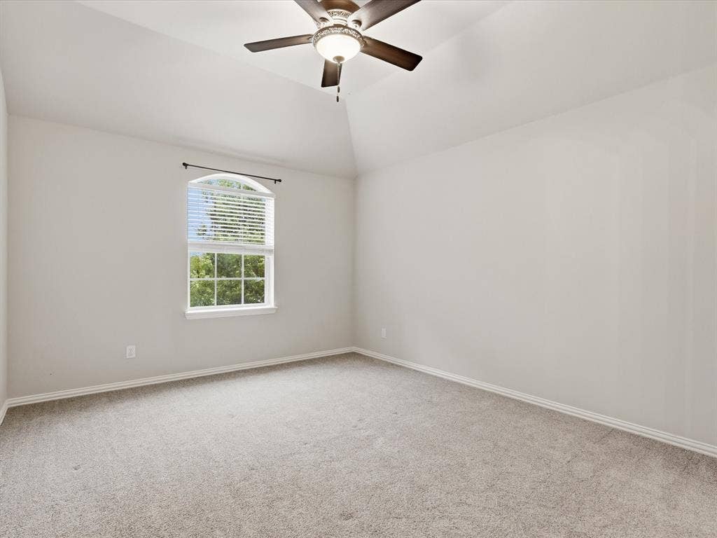 1621 Lakemere Drive, Prosper, TX 75078 Light-filled room featuring vaulted ceilings, an arched window, a ceiling fan with integrated lighting, and neutral carpeting