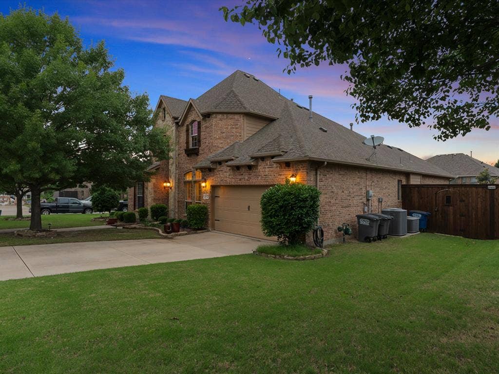 1621 Lakemere Drive, Prosper, TX 75078 Brick exterior with a gabled roofline, an integrated garage, a concrete driveway, and mature landscaping
