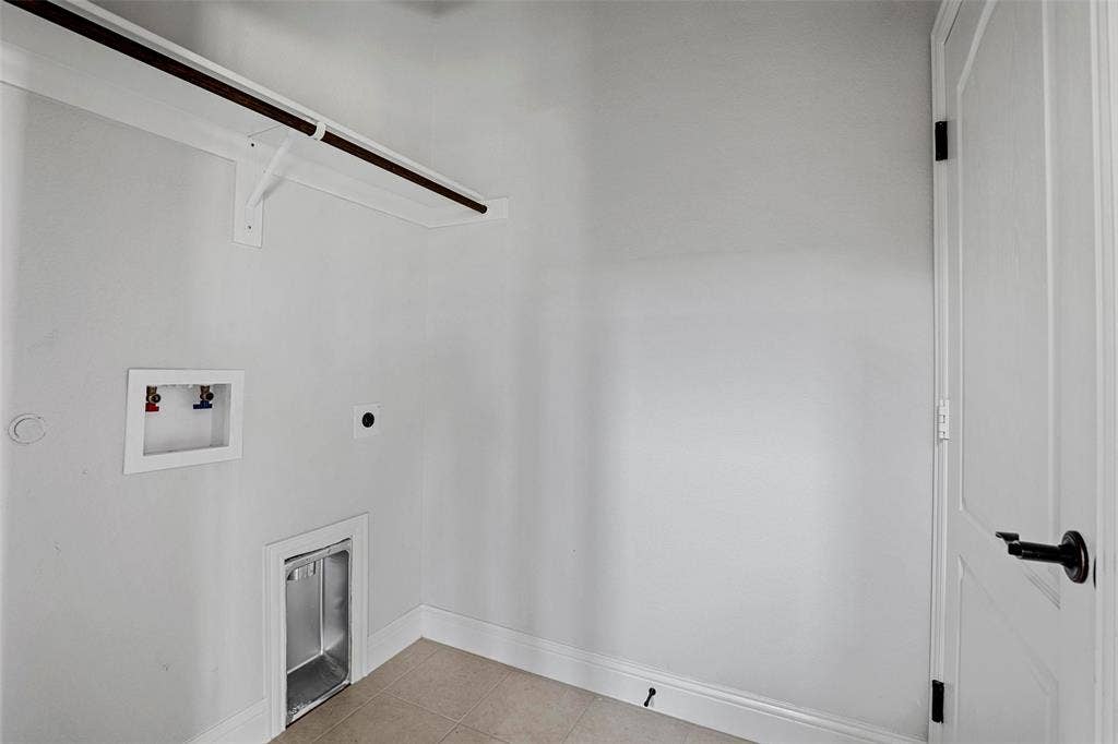 508 Bush Avenue, Waxahachie, TX 75165 Dedicated utility space featuring light-toned flooring, white wall paint, and a white interior door with matte black hardware