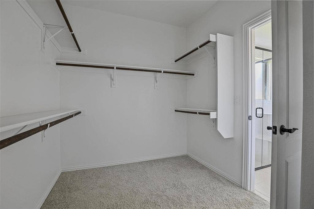 508 Bush Avenue, Waxahachie, TX 75165 Walk-in closet with carpet flooring, multiple shelving units, and clothing rods