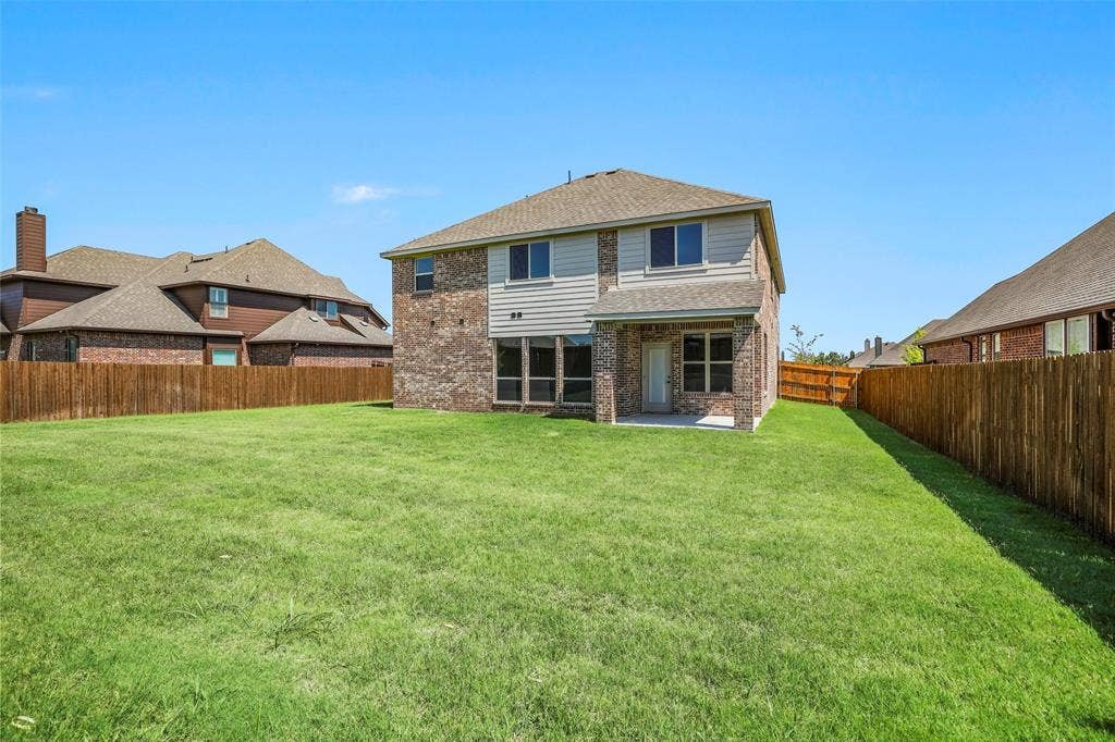 508 Bush Avenue, Waxahachie, TX 75165 Spacious backyard featuring a large green lawn and complete privacy fencing