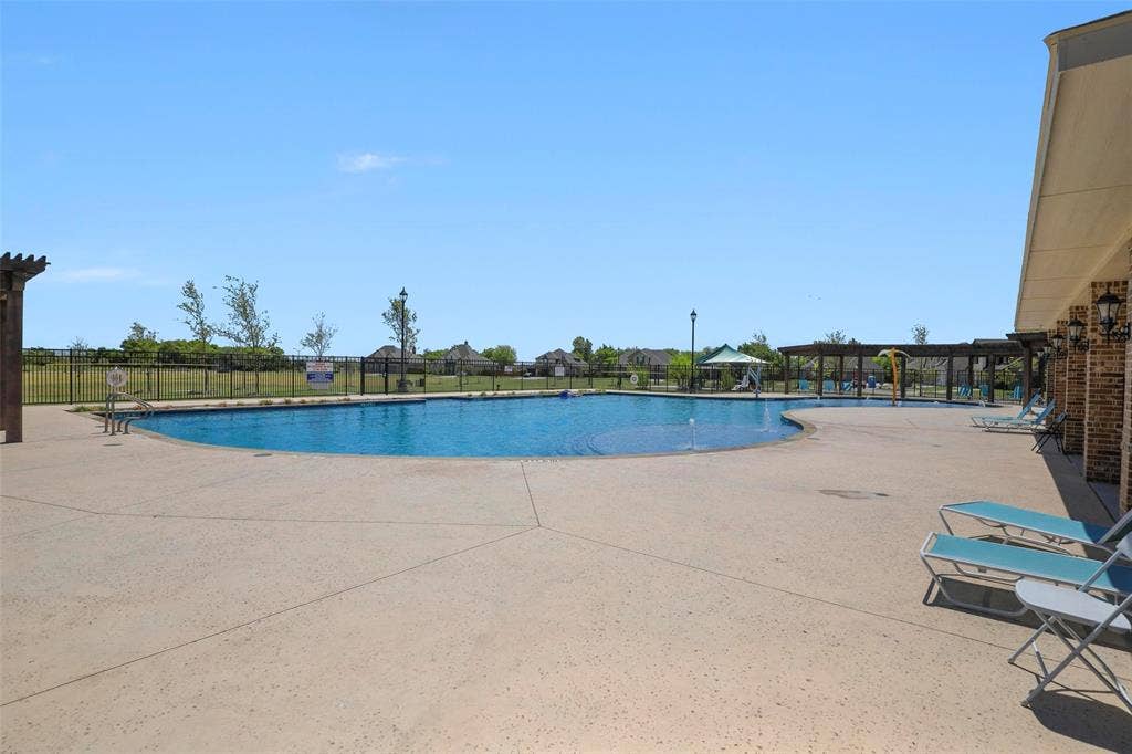 508 Bush Avenue, Waxahachie, TX 75165 Expansive resort-style swimming pool featuring a curved design and integrated water features
