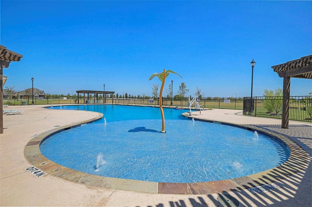 508 Bush Avenue, Waxahachie, TX 75165 Resort-style pool with integrated splash pad, multiple water features, and expansive concrete decking