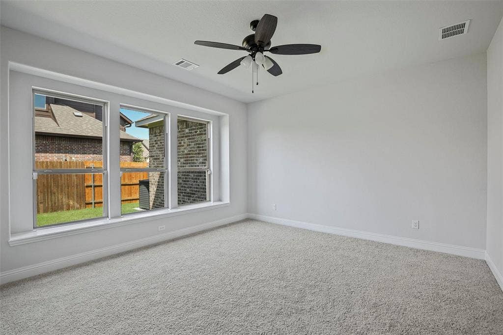 508 Bush Avenue, Waxahachie, TX 75165 Spacious room featuring light gray carpeting, neutral wall finishes, and a dark-toned ceiling fan