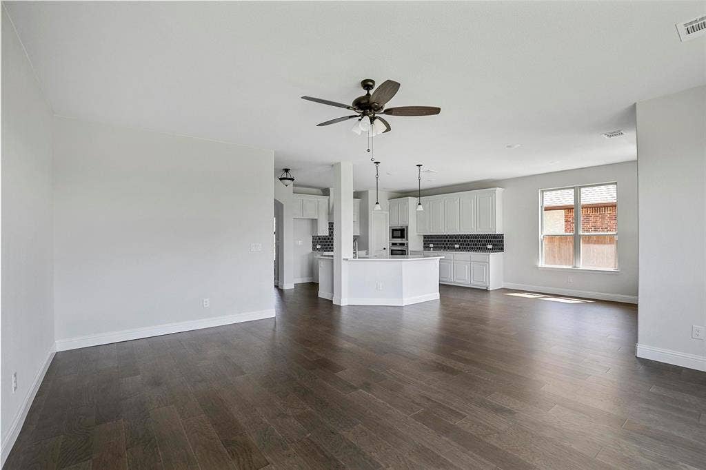 508 Bush Avenue, Waxahachie, TX 75165 Spacious open-concept interior featuring wood-finish flooring, white walls, and a ceiling fan