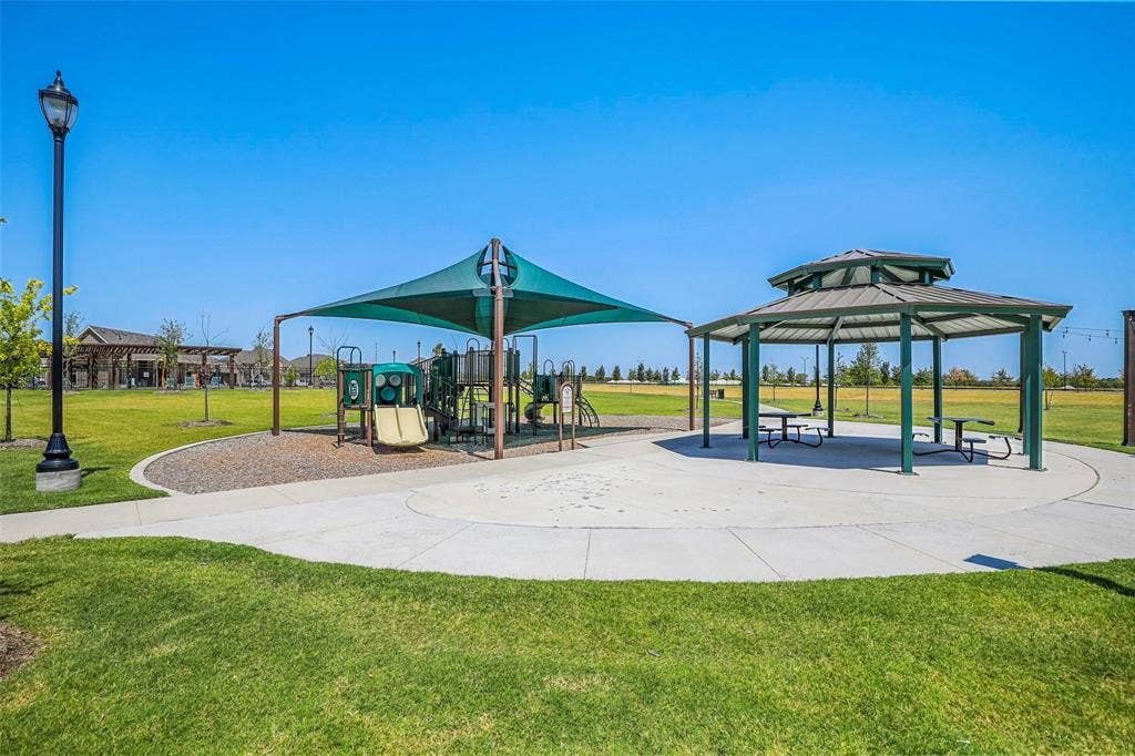 508 Bush Avenue, Waxahachie, TX 75165 Community park featuring a play structure with a shade canopy, a hexagonal gazebo, picnic tables, and a paved walkway