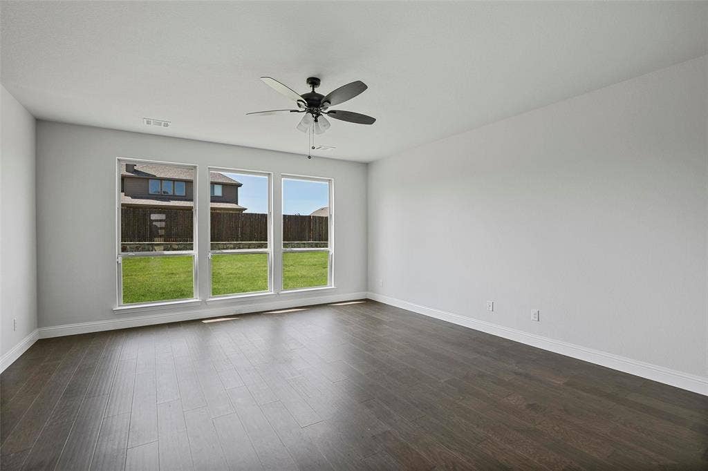 508 Bush Avenue, Waxahachie, TX 75165 Spacious room featuring dark wood-finish flooring, light gray walls, and white baseboards