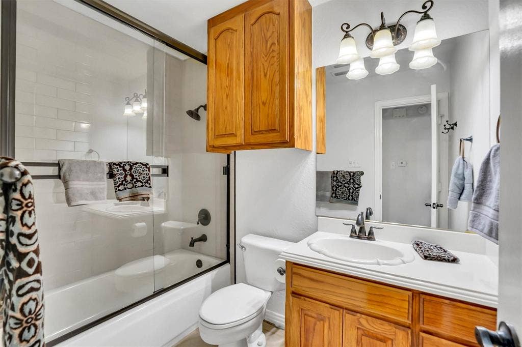 428 Shelby Drive, Burleson, TX 76028 Bathroom featuring a tub/shower combination with subway tile surround and glass enclosure