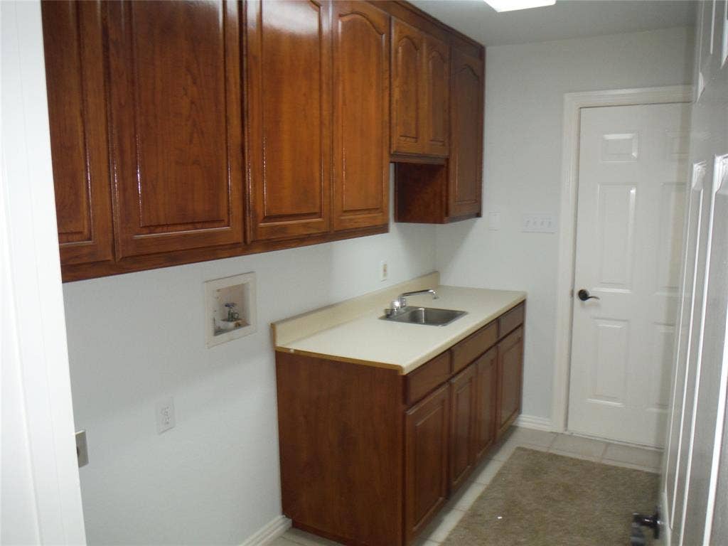 428 Shelby Drive, Burleson, TX 76028 Nice utility room loaded with cabinets and a sink.