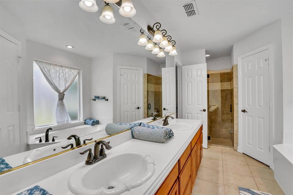 428 Shelby Drive, Burleson, TX 76028 Dual sink vanity with white countertops and wood-finish cabinetry
