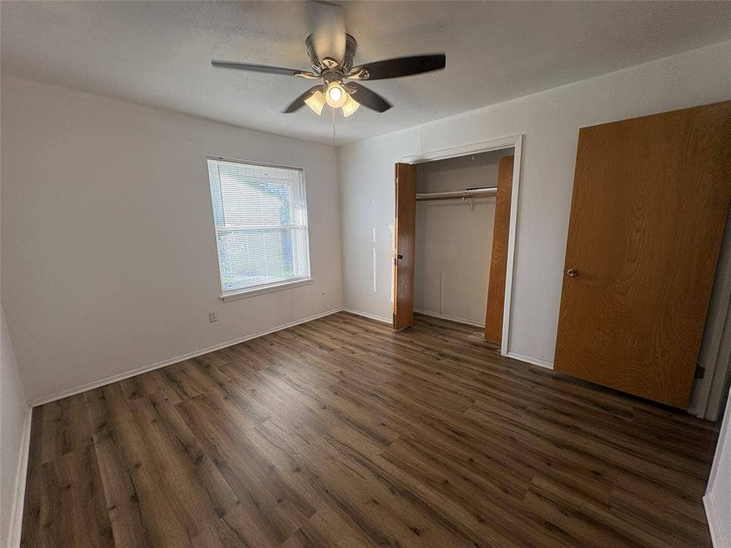6100 Landmark Drive, Waco, TX 76710 Room featuring wood-finish flooring, a ceiling fan with integrated lighting, and a window with blinds