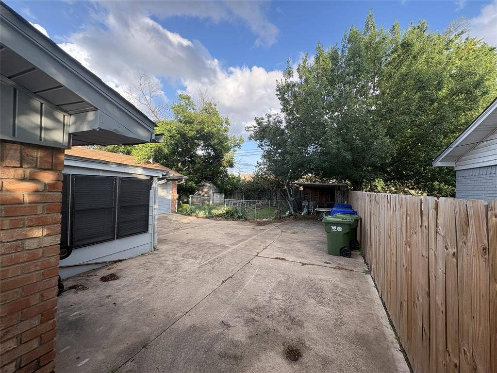 6100 Landmark Drive, Waco, TX 76710 Concrete patio area featuring a wood privacy fence and mature trees