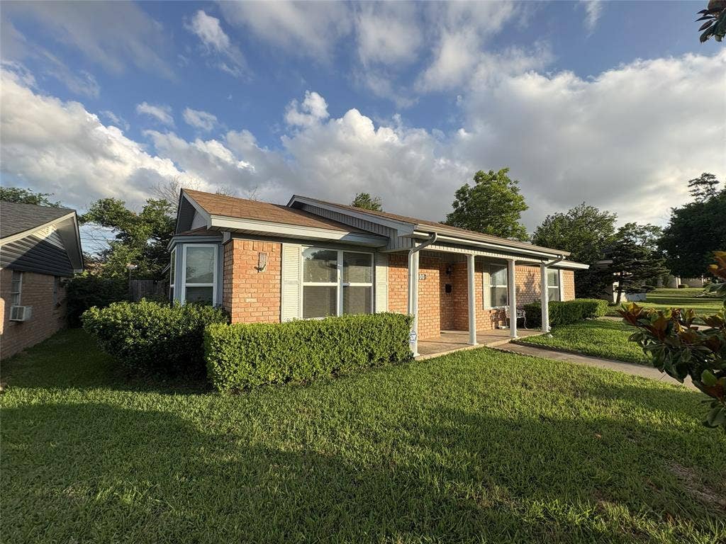 6100 Landmark Drive, Waco, TX 76710 Brick exterior featuring a covered porch, bay window, and manicured shrubbery