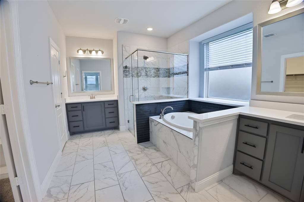 620 Shadow Trail, Frisco, TX 75033 Contemporary bathroom featuring dual vanities with quartz countertops, a built-in soaking tub, a glass-enclosed shower, and large format tile flooring