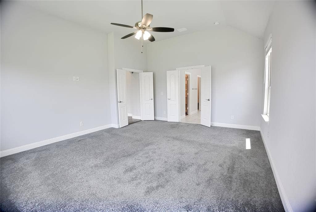 620 Shadow Trail, Frisco, TX 75033 Spacious room featuring vaulted ceilings, a ceiling fan with integrated lighting, plush grey carpeting, and white baseboards