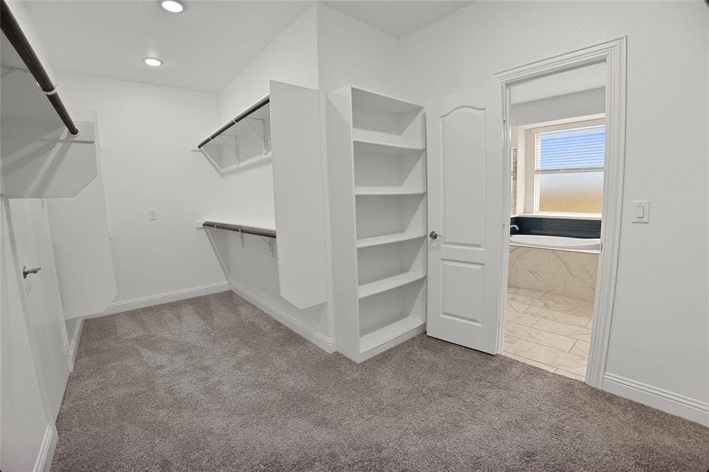 620 Shadow Trail, Frisco, TX 75033 Walk-in closet with carpet flooring, recessed lighting, built-in shelving, and direct access to a bathroom featuring a soaking tub