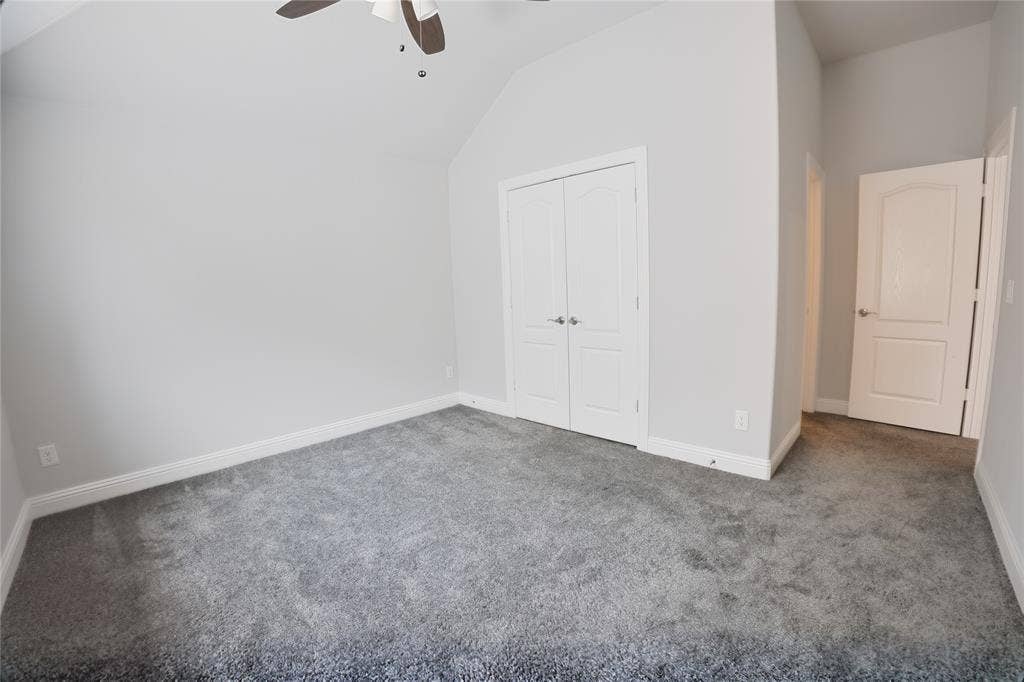 620 Shadow Trail, Frisco, TX 75033 Carpeted room featuring a vaulted ceiling with a ceiling fan, white baseboards, and bright white interior doors