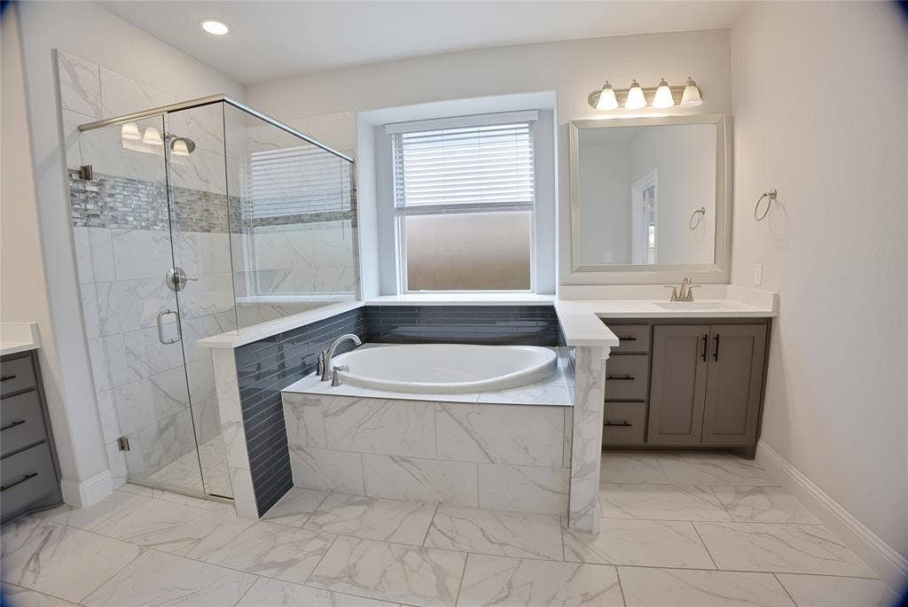 620 Shadow Trail, Frisco, TX 75033 Spacious bathroom featuring a glass-enclosed shower with tile surround, separate soaking tub, and a single vanity with storage