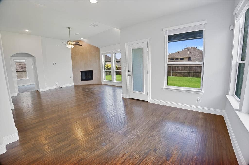 620 Shadow Trail, Frisco, TX 75033 Spacious living area featuring wood-finish flooring, a fireplace with a stone-finish surround, vaulted ceilings, and recessed lighting