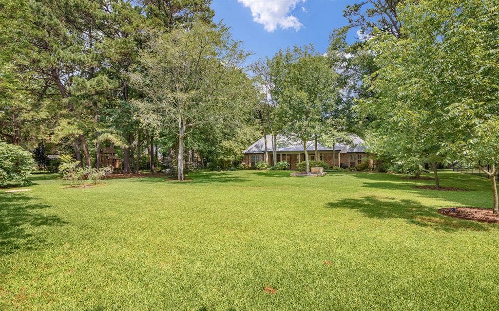 1915 Stonegate Valley Drive, Tyler, TX 75703 Expansive green lawn surrounded by mature trees,