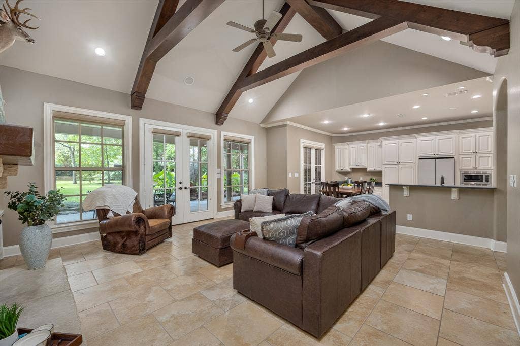 1915 Stonegate Valley Drive, Tyler, TX 75703 Spacious living area featuring a vaulted ceiling with exposed wood beams, recessed lighting, and a ceiling fan