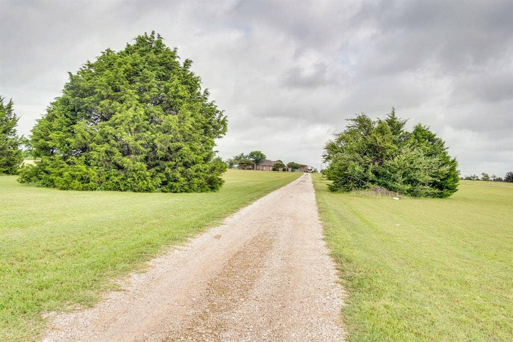 431 Mcalpin Road, Midlothian, TX 76065 Gravel driveway with expansive green lawn and mature trees