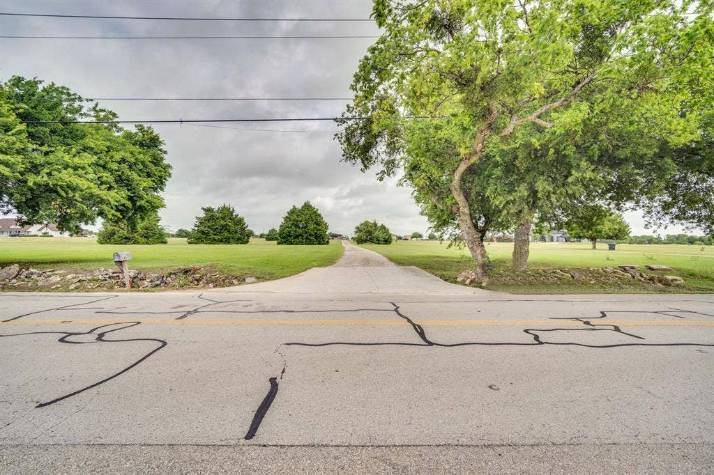 431 Mcalpin Road, Midlothian, TX 76065 Paved driveway entrance with abundant green space and mature trees