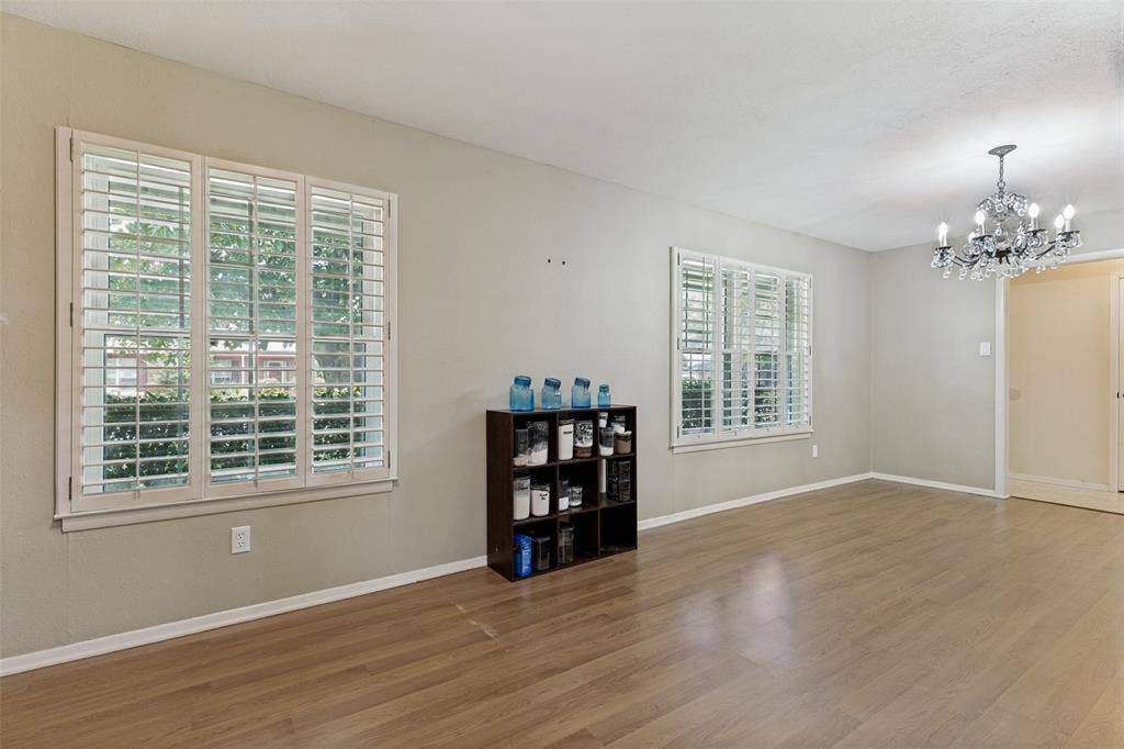 1121 W Redbud Drive, Hurst, TX 76053 Dining room featuring wood flooring, crystal chandelier, and white wood shutters