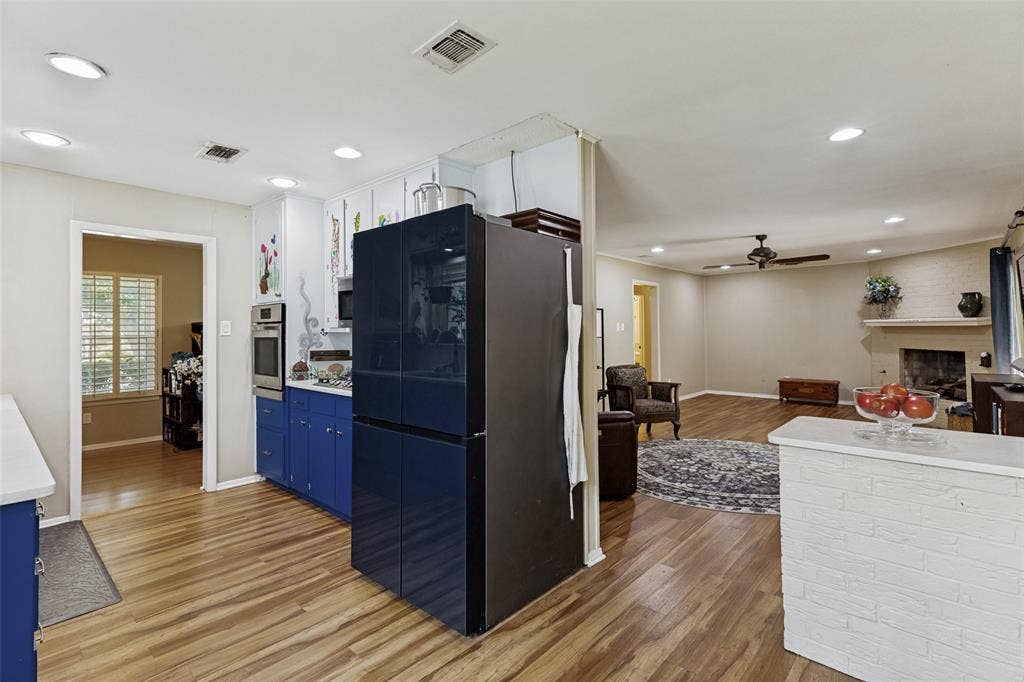 1121 W Redbud Drive, Hurst, TX 76053 Kitchen area featuring wood-finish flooring, recessed lighting, and blue lower cabinetry