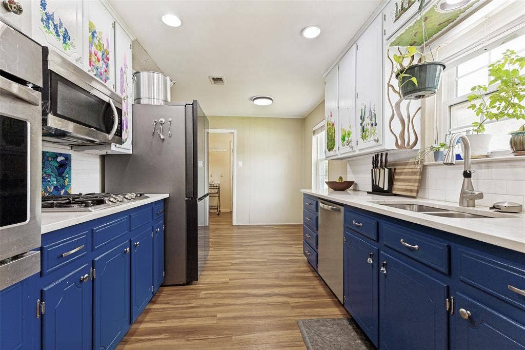 1121 W Redbud Drive, Hurst, TX 76053 Kitchen featuring wood-finish flooring, white countertops, and blue lower cabinetry
