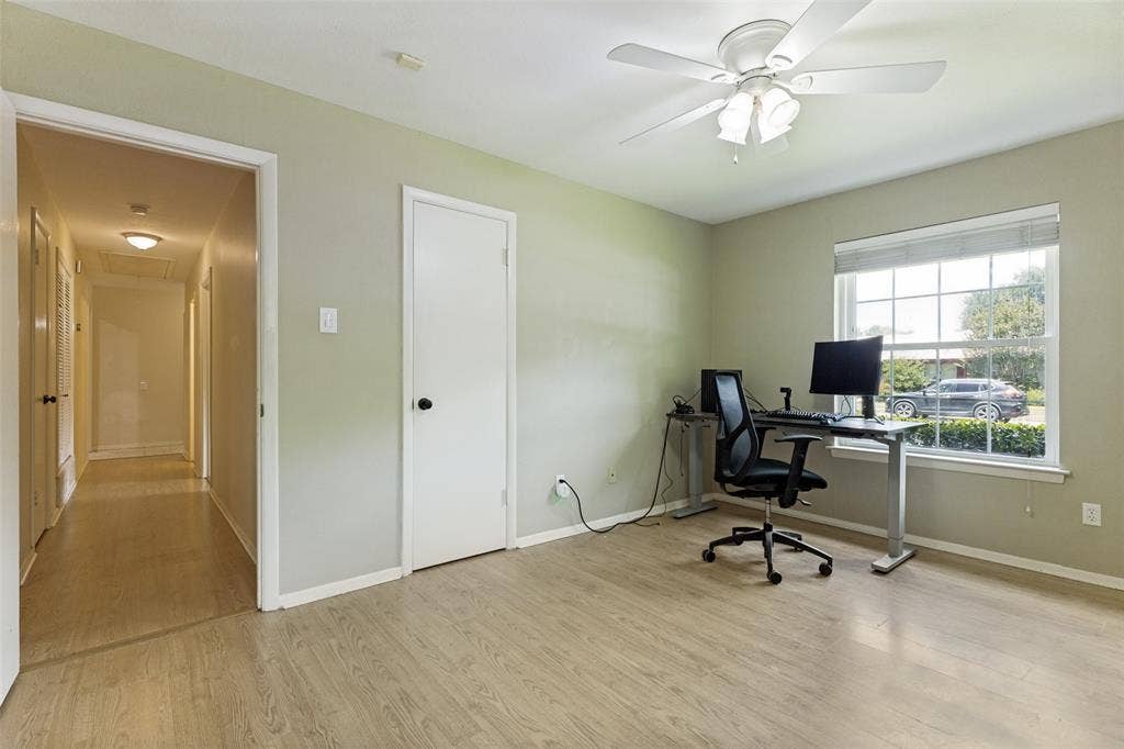 1121 W Redbud Drive, Hurst, TX 76053 Secondary bedroom r featuring wood-finish flooring, a large window with blinds, and a ceiling fan with integrated lighting