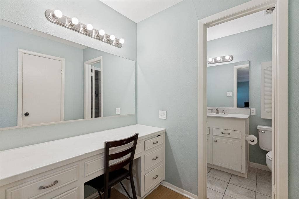 1121 W Redbud Drive, Hurst, TX 76053 Built-in vanity with extensive counter space, mirror, and overhead strip lighting