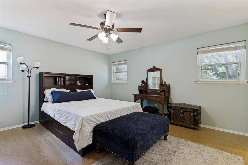 1121 W Redbud Drive, Hurst, TX 76053 Bedroom featuring wood-finish flooring, light blue walls, and a ceiling fan with integrated lighting