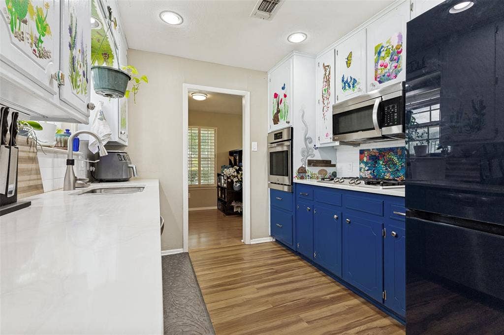 1121 W Redbud Drive, Hurst, TX 76053 Contemporary kitchen featuring bright white countertops, wood-finish flooring, and recessed lighting