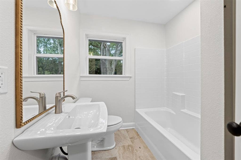 608 Bunny Rabbit Road, Athens, TX 75751 Bathroom featuring a pedestal sink with a brushed nickel faucet, a framed mirror, and a window
