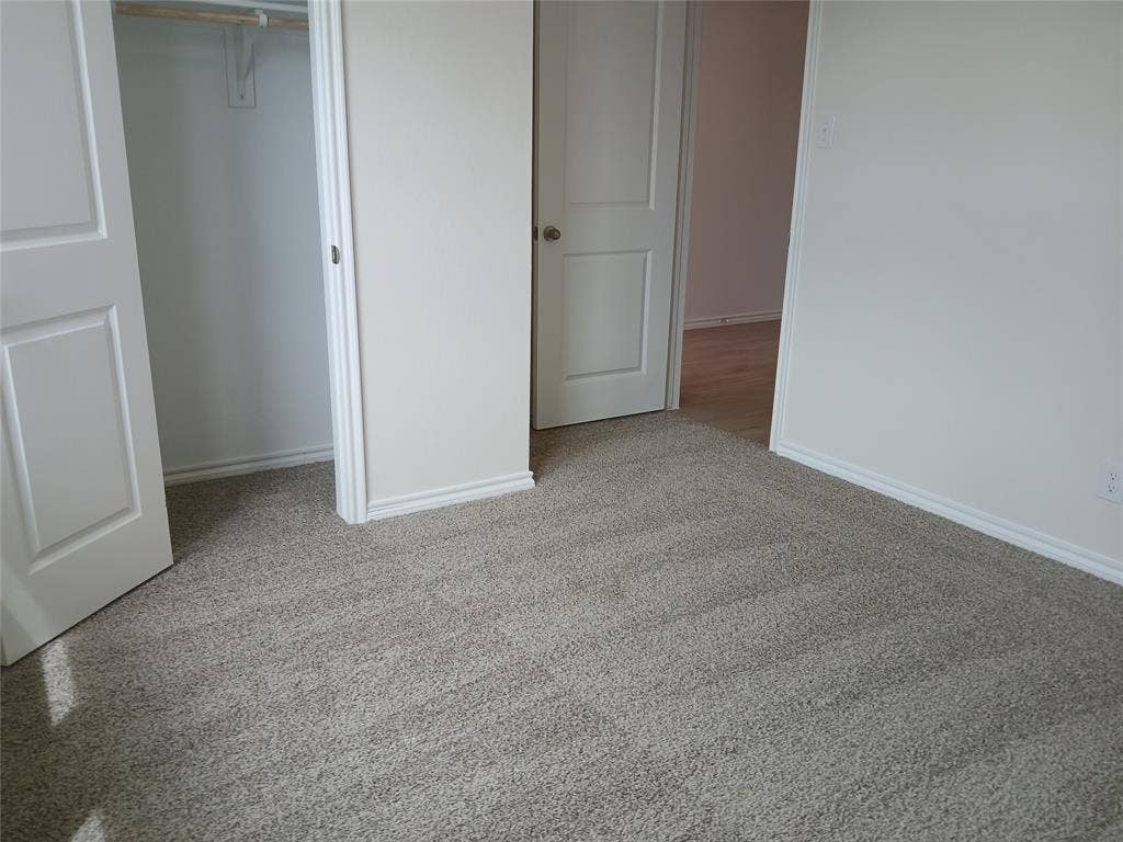 312 Whispering Pine Drive, Royse City, TX 75189 Gray carpet flooring in a neutral room with white walls and baseboards