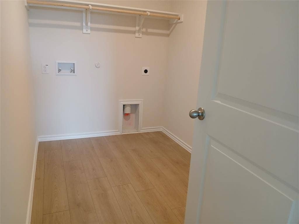 312 Whispering Pine Drive, Royse City, TX 75189 Dedicated utility space featuring light wood-finish flooring, white walls, and a built-in hanging rod