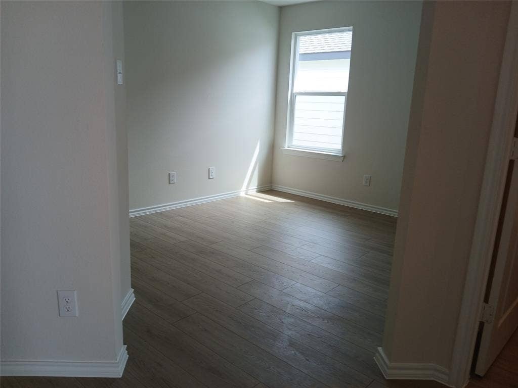 312 Whispering Pine Drive, Royse City, TX 75189 Room featuring wood-finish flooring, a single window with blinds, and light-toned wall paint