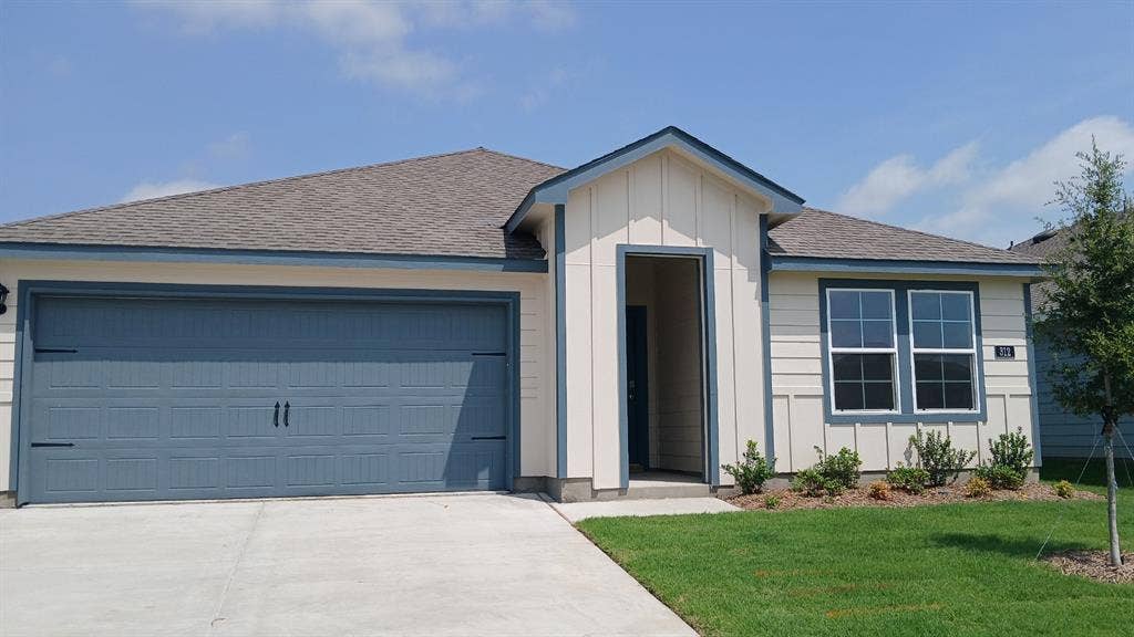 312 Whispering Pine Drive, Royse City, TX 75189 Contemporary single-story residence featuring a two-car garage, a covered entry, horizontal siding, and a gabled roofline