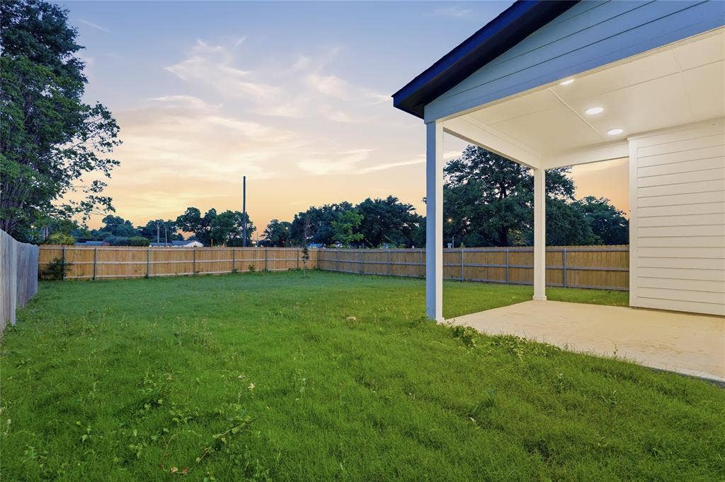 2212 Marburg Street, Dallas, TX 75215 Expansive backyard featuring a manicured lawn, full privacy fencing, and mature perimeter trees
